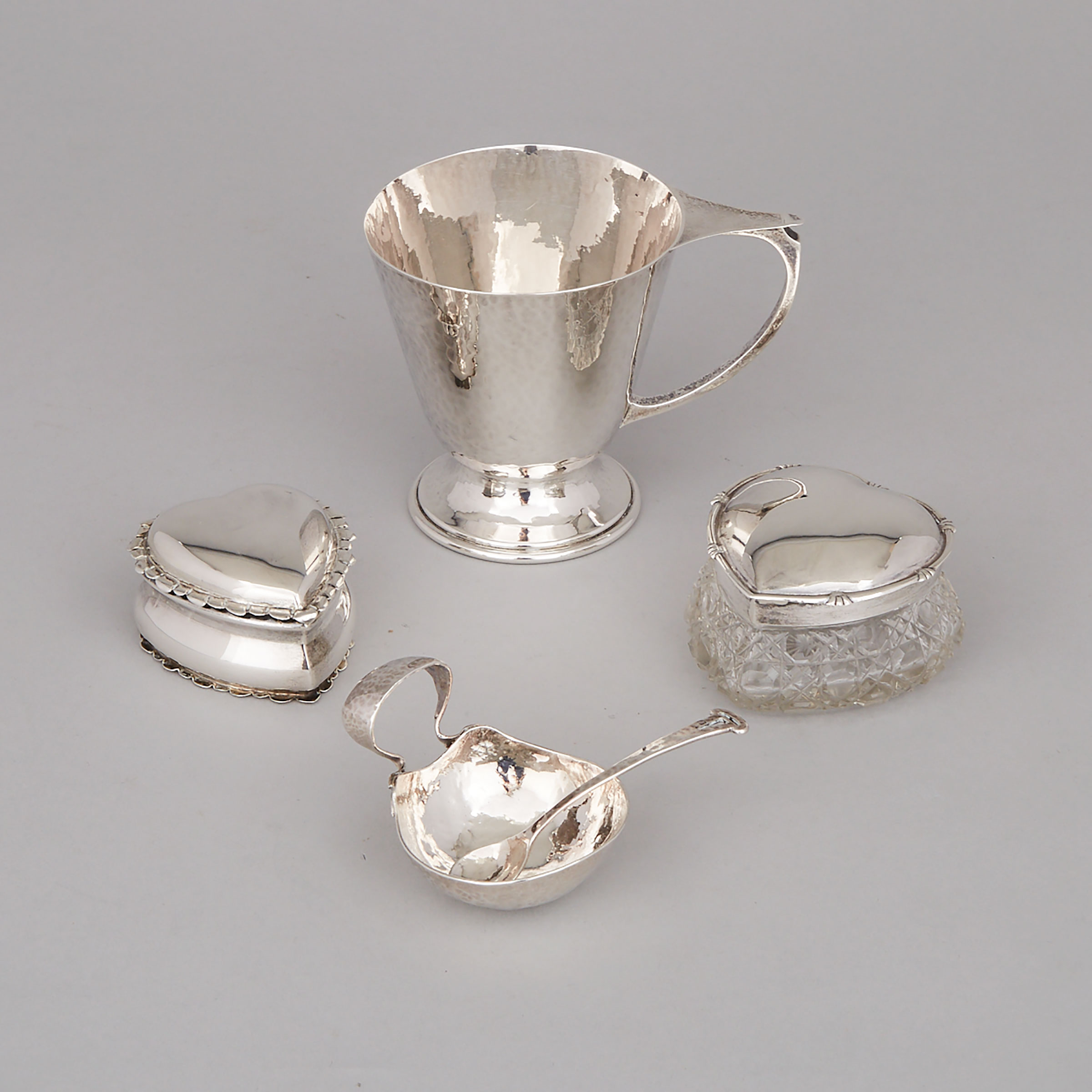 English Silver Mug, A.E. Jones, Birmingham, 1919, Two Edwardian Heart Shaped Boxes, 1903/07 and an Arts & Crafts Salt Cellar with Spoon, 20th century