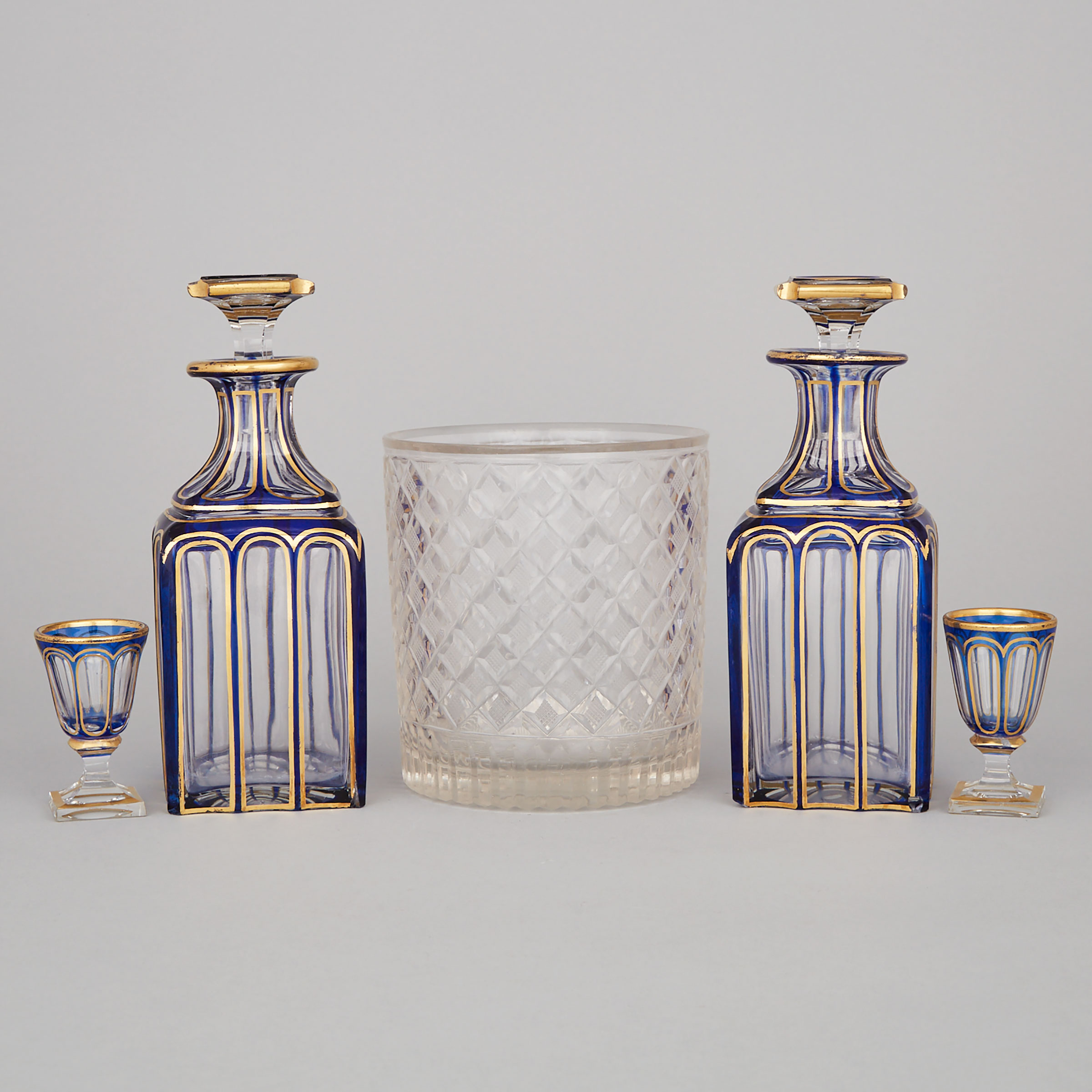 Pair of Bohemian Blue Overlaid and Gilt Glass Decanters with Stoppers and Two Glasses and a Cut Glass Ice Bucket, 20th century