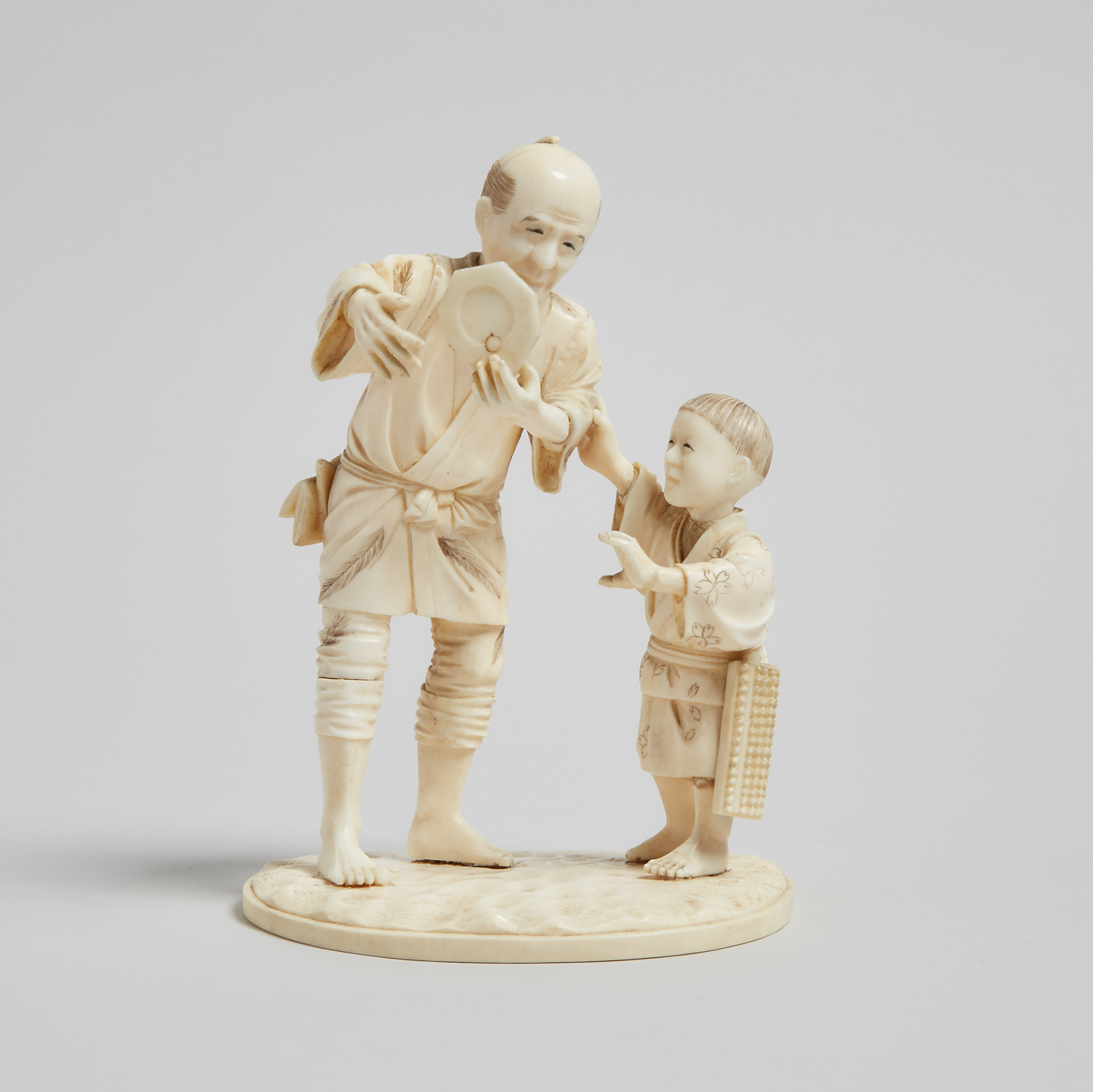 An Ivory Carved Okimono of a Man and Child, Meiji Period